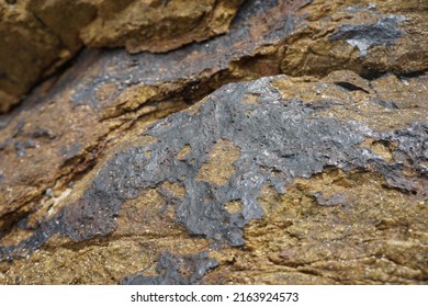 Raw Tin Metal Ore Stuck On Rock.