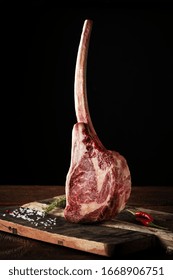 Raw Tomahawk Steak On A Beef Bone Dry Aged On A Dark Background