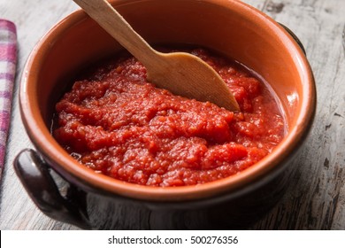 Raw Tomato Sauce In A Crock Pot Resting On The Table With Wooden Spoon