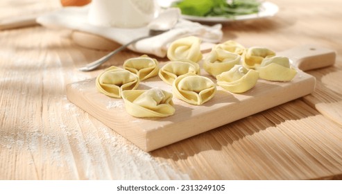 raw tortelloni with spinach on a wooden board. fresh pasta with ricotta cheese and green leaves. traditional italian food. dish mediterranean cuisine. - Powered by Shutterstock