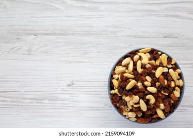 Raw Trail Mix With Nuts And Fruits In A Bowl On A White Wooden Background, Top View. Flat Lay, Overhead, From Above. Copy Space.