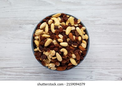 Raw Trail Mix With Nuts And Fruits In A Bowl On A White Wooden Background, Top View. Flat Lay, Overhead, From Above.