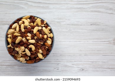 Raw Trail Mix With Nuts And Fruits In A Bowl On A White Wooden Background, Top View. Flat Lay, Overhead, From Above. Space For Text.