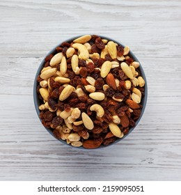 Raw Trail Mix With Nuts And Fruits In A Bowl On A White Wooden Background, Top View. Flat Lay, Overhead, From Above. 