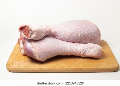 Raw Turkey Leg On A Wooden Board On A White Background. Fresh Turkey Meat