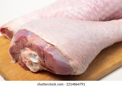 Raw Turkey Leg On A Wooden Board On A White Background. Fresh Turkey Meat