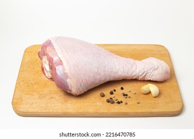 Raw Turkey Leg On A Wooden Board On A White Background. Fresh Turkey Meat