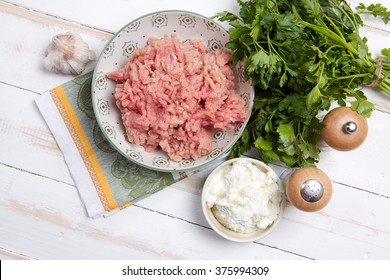 Raw Turkey Mince, Cottage Cheese, Garlic, Parsley, Salt And Pepper On White Table