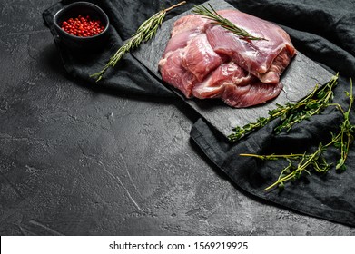 Raw Turkey thigh fillet. Farm eco meat. Dark background. Top view. Space for text.
