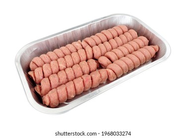 Raw turkey twizzlers in a foil tray, turkey meat formed into spirals isolated on a white background