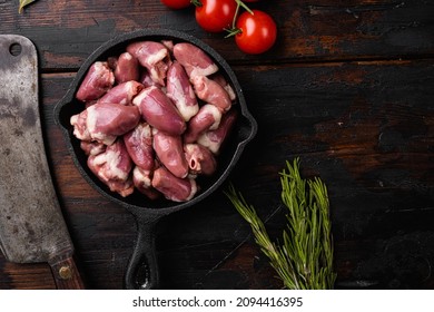 Raw uncooked chicken gizzards, chicken hearts set, on old dark  wooden table background, top view flat lay, with copy space for text