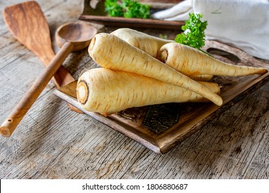 raw and uncooked parsnips on a wooden table - Shutterstock ID 1806880687
