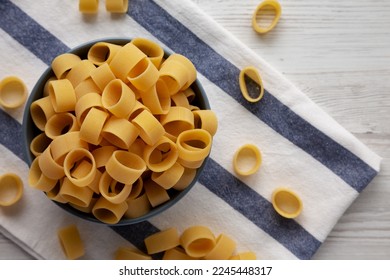 Raw Uncooked Pasta Calamarata in a Bowl, top view. Flat lay, overhead, from above. Copy space. - Shutterstock ID 2245448317