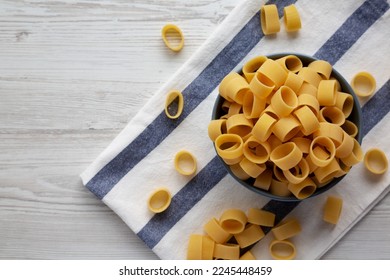 Raw Uncooked Pasta Calamarata in a Bowl, top view. Flat lay, overhead, from above. Copy space. - Shutterstock ID 2245448459