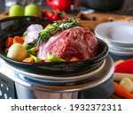 raw and uncooked Roast pork with root vegetables in a slow cooker