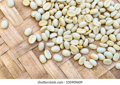 raw, unroasted coffee beans drying in sunlight