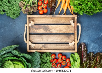 Raw Vegan Background, Organic Vegetables Broccoli Cauliflower Carrots Tomatoes Kale Pak Choy Onions With Wooden Box. Healthy Local Farm Produce On Blue Concrete Table, Top View, Selective Focus