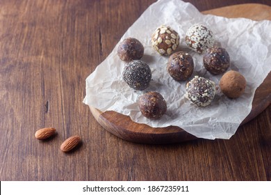 Raw Vegan Healthy Energy Balls With Oatmeal, Chia Seed, Coconut Flakes, Cocoa, Almond And Dried Fruits On Dark Wooden Background. No Cook Energy Bites.