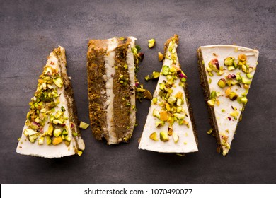 Raw Vegan Pistachio Carrot Cake With Cashew Cream Layers From Above On Concrete Table. Dark Food Photography Styling Concept.