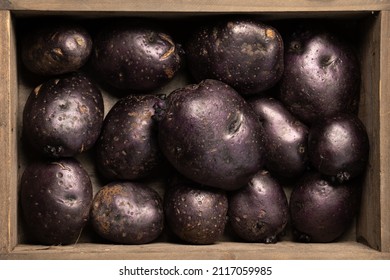 Raw Vitelotte Violet Potatoes In A Wooden Box. Above View