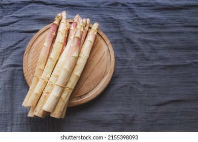 raw white asparagus tied in bunch served on wooden board. top view, copy space. Farmers high quality products, fresh pink asparagus in spring season