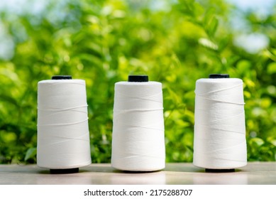 Raw White Polyester FDY Yarn Spool With Green Blurred Background