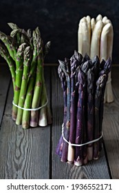 Raw White, Purple, Green Asparagus On A Dark Wooden Background. 