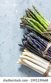 Raw White, Purple, Green Asparagus On A Blue Background. Raw Food Concept, Place For Copy Space.