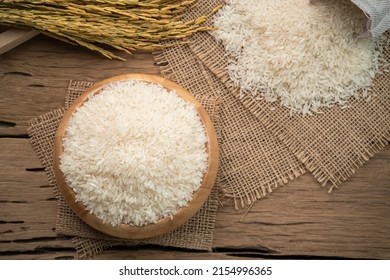 Raw White Rice (Uncooked) In Wooden Bowl On Wood Plate