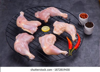 Raw Whole Chicken Leg Without Skin Arranged On A Grill  And Garnished With Lemon Slices,red Chilli Chilli Flakes And Pepper  On Grey Or Graphite Texture Background