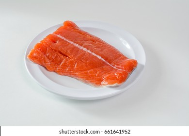 Raw wild king Salmon Fillet lying on white place, against white background
