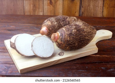 raw yam over rustic wooden table. Also known as Alocasia, Colocasia, Xanthosoma. top view