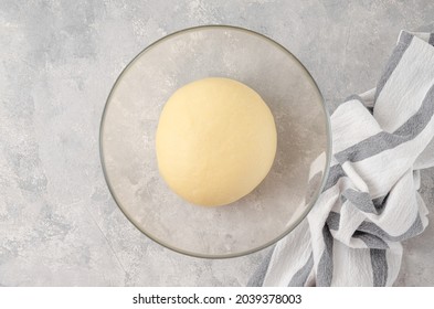 Raw yeast dough in a bowl on a gray concrete background. Dough for making sweet bread, brioche or challah bread on a gray concrete background. Top view - Powered by Shutterstock