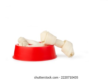 Rawhide Bones In A Red Pet Bowl On A White Background