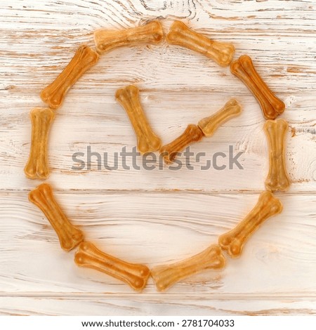 Rawhide dog bones arranged in a circular shape on a rustic wooden background.