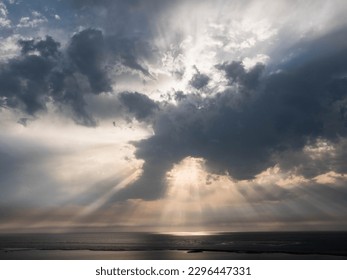ray of the sun breaking through a cloud above the ocean - Shutterstock ID 2296447331