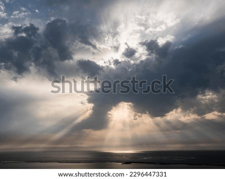 ray of the sun breaking through a cloud above the ocean
