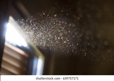 A ray of sun coming through the wooden shutters, illuminates dust on the inside of a dark room. Close up, selective focus. Vintage background. - Powered by Shutterstock