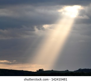 A ray of sunlight breaking through dark clouds.