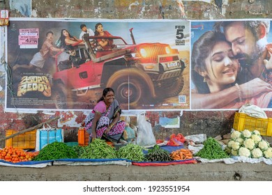 Rayagada, India - February 2021: A Woman Selling Vegetables Next To Bollywood Movie Posters In The Rayagada Market On February 16, 2021 In Rayagada, Odisha, India.