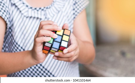 Rayong Province, Thailand - March 8th, 2018:  kids hands plaiyng with the Rubik's Cube. Rubik's cube invented by a Hungarian architect Erno Rubik in 1974. - Shutterstock ID 1041101464