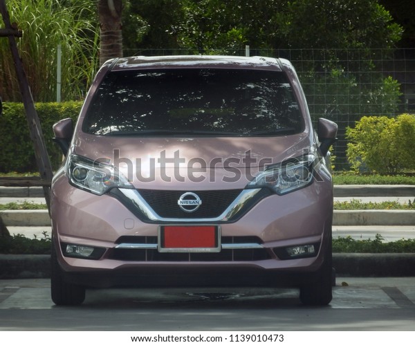 Rayong, Thailand - July 21st, 2018: Front\
view of a Nissan Note eco-car with red number plate signifying its\
a new car awaiting completed registration.\
