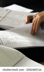 Rayong, Thailand - March 10th, 2018: Close Up Detail Of A Teacher's Hand Grading A Bundle Of School Student Exam Papers And Answer Sheets At The End Of Term.