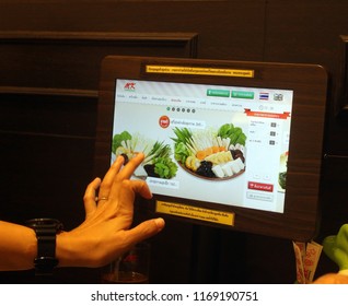 Rayong, Thailand - September 1st, 2018: A Customer Orders Food By Using A Digital Touchscreen Menu At Their Table Inside An MK Restaurant. MK Restaurants Is The Most Popular Suki Chain In Thailand.