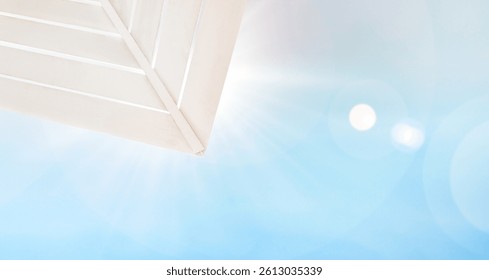 rays of bright sun shining through beach umbrella, summer background
