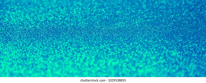 rays of light in blue and green sequins background