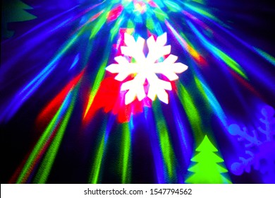 rays of light on a black background. Colored snowflakes and christmas trees