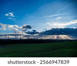 Rays of light penetrate the dark cloudy sky