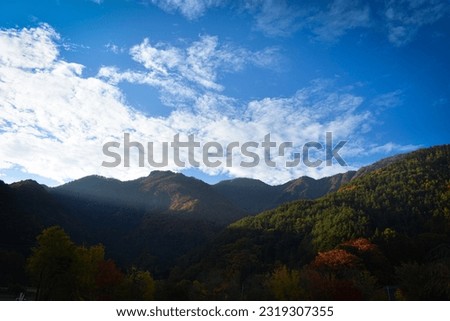 Rays of light setting behing a mountain range, near FujiKawaguchiko in Japan, during autumn.