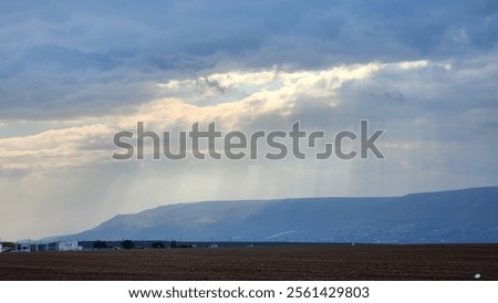 Rays of light shine through an open window in the sky between the winter stormy clouds over Israel, the Holy Land